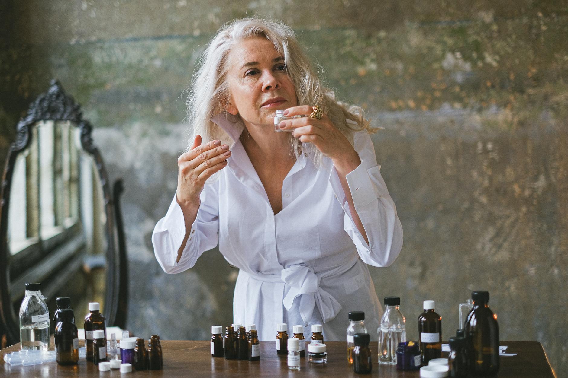 a woman with gray hair holding a small bottle